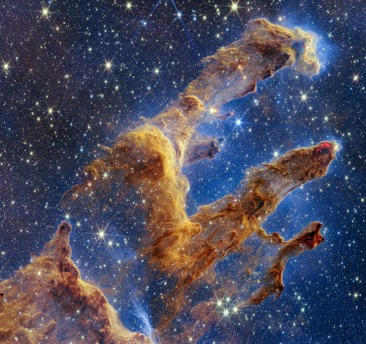 Webb NIRCam view of the Pillars of Creation, with tall cloud structures against a field of stars.